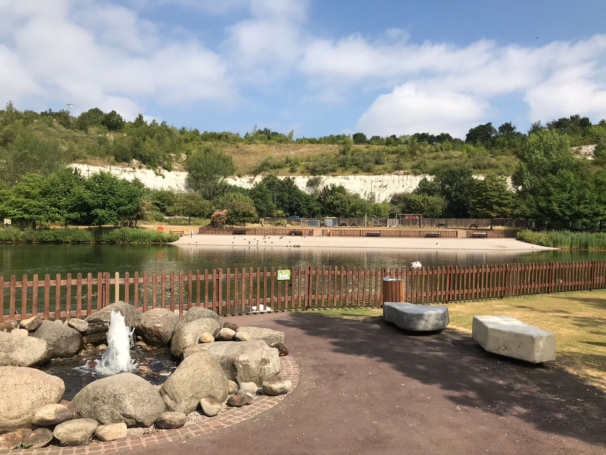 View as you enter Bluewater Nature Trail, the large lake in the foreground with chldren's assault course on the other side of the lake and white chalk cliffs in the distance.