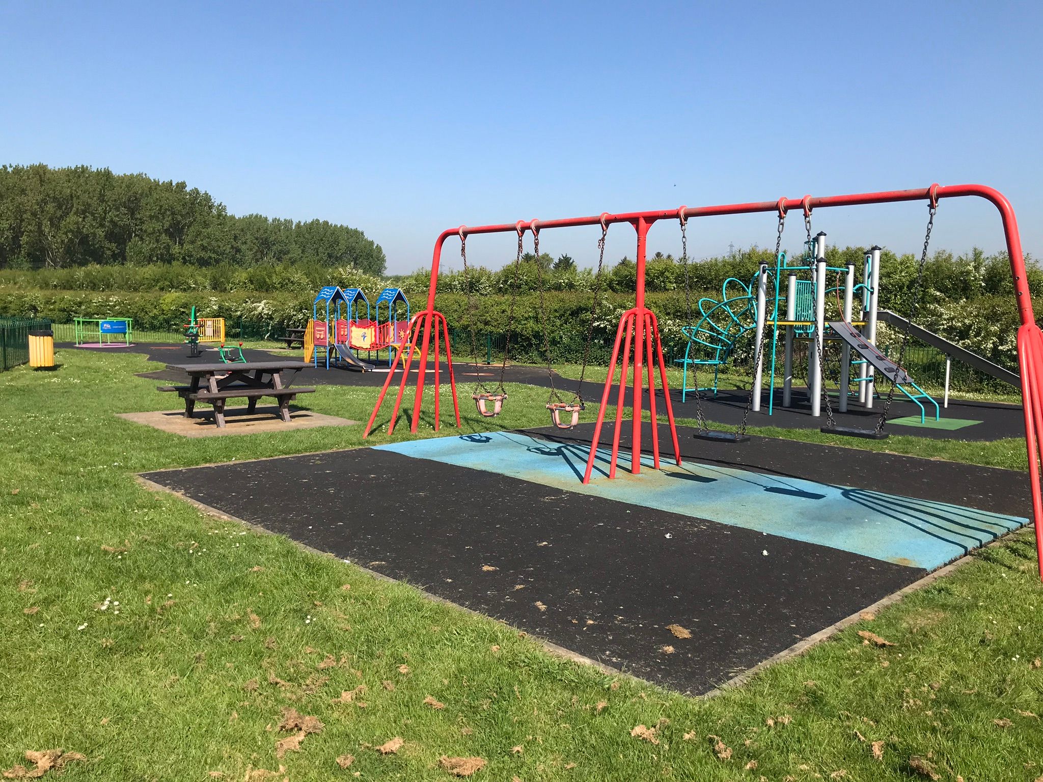 Gated play area with swings and climbing frames.