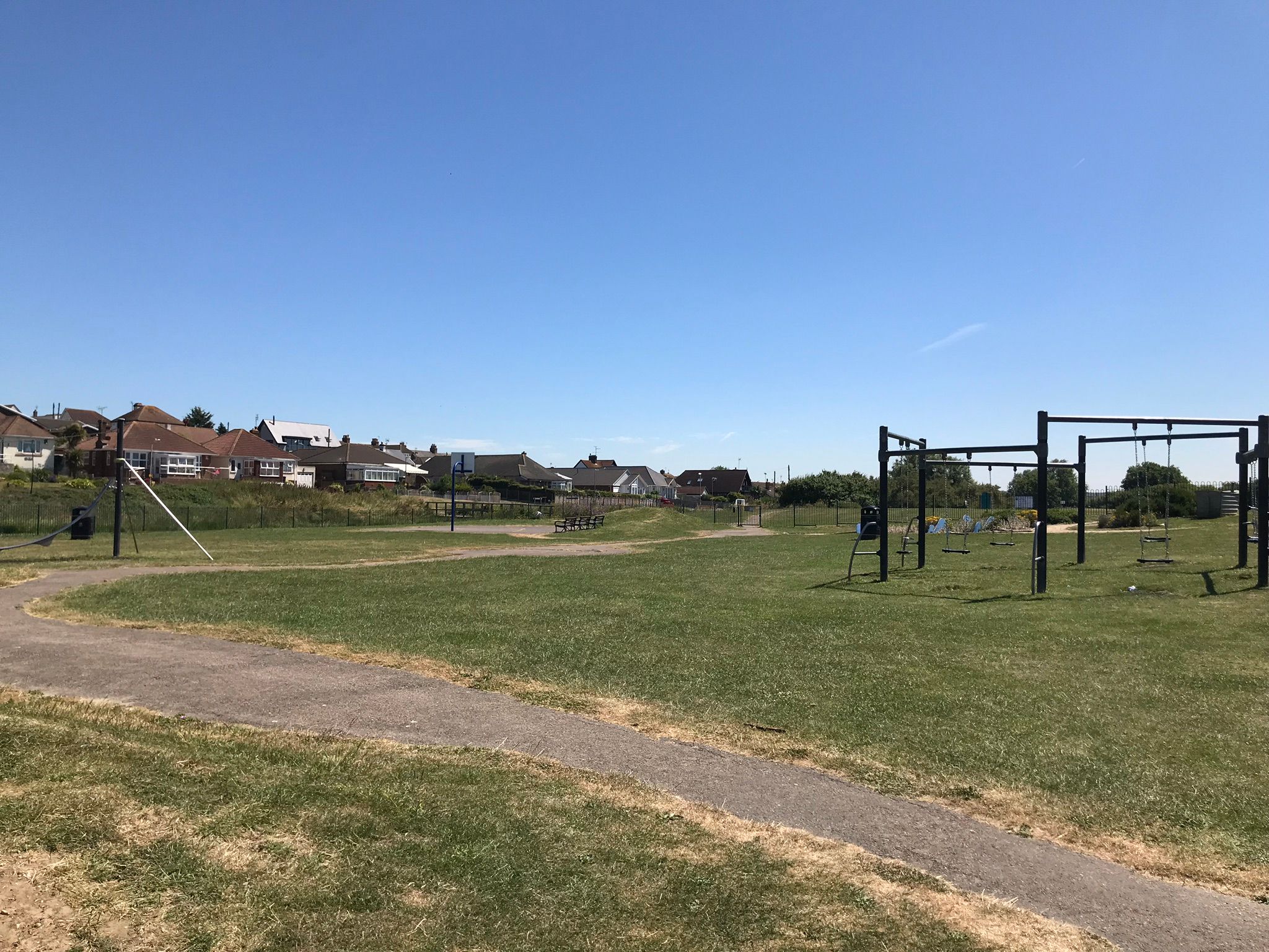 Hampton play area with a view of the circular swing set and basket ball court.