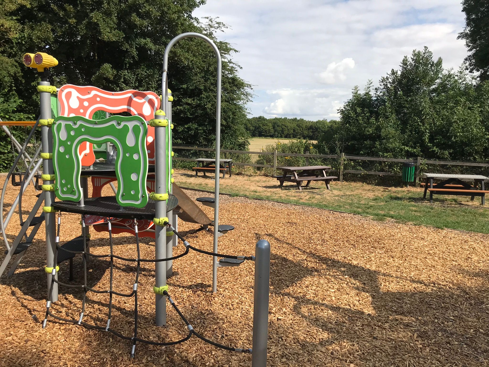 The smaller climbing frame and picnic benches at Lordswood play area