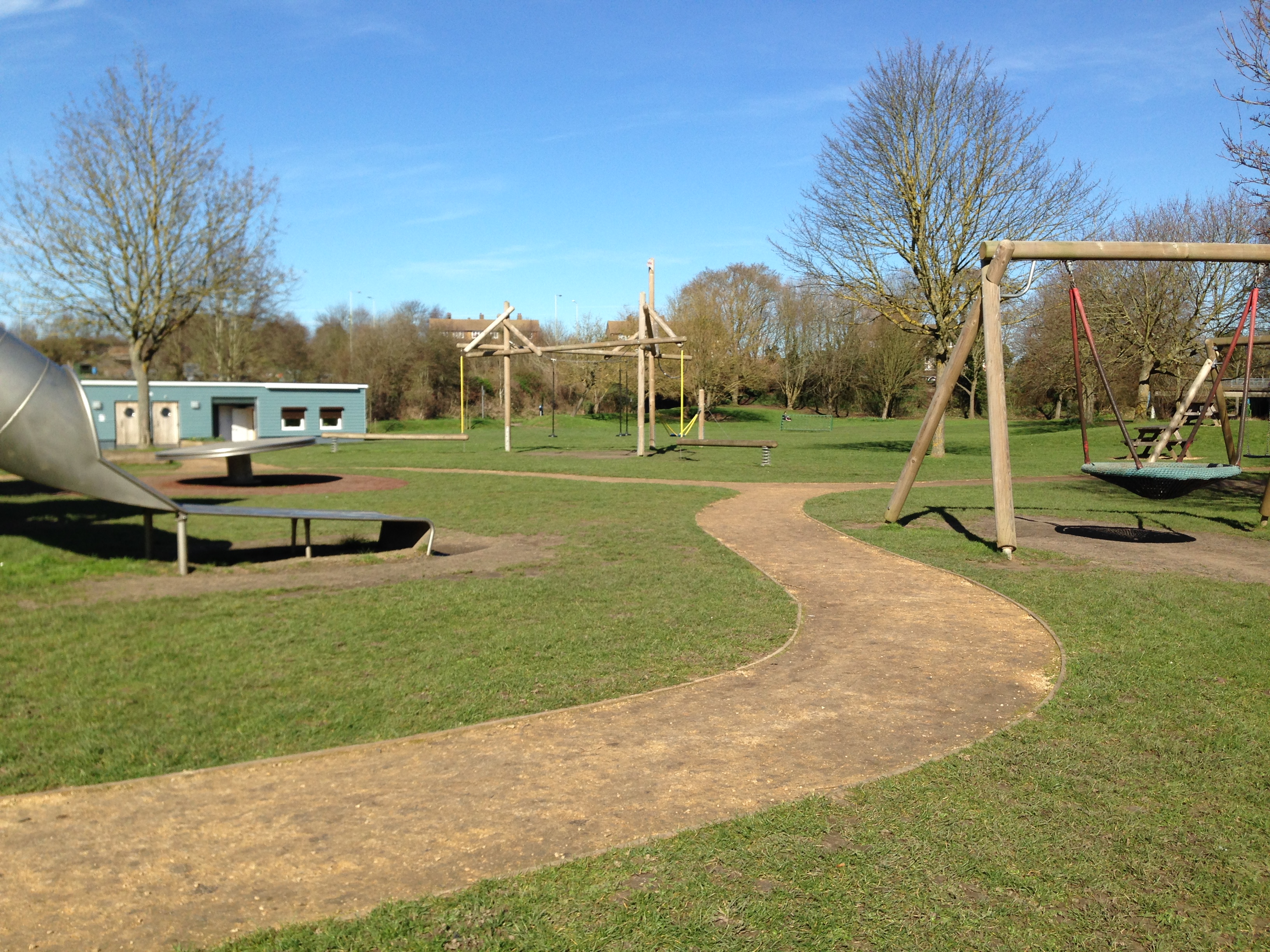 view of the play equipment and wardens building with toilets