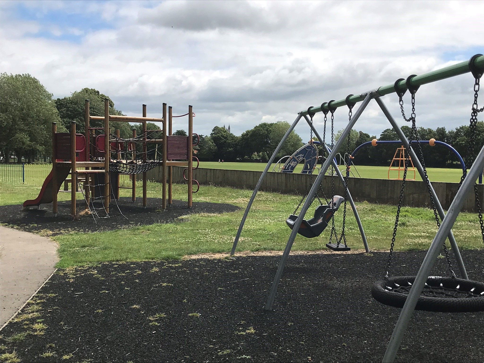 accessible swings and larger climbing frame in the background.